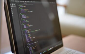 professional programmer sitting in front of several screens